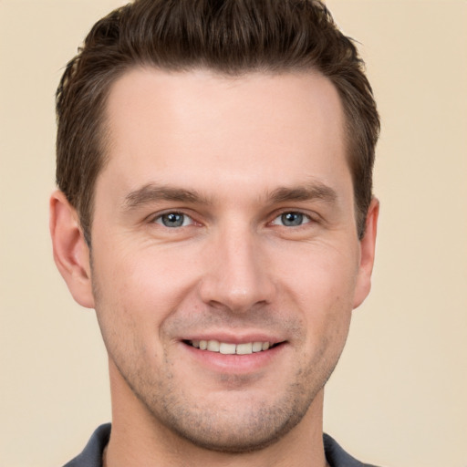 Joyful white young-adult male with short  brown hair and grey eyes