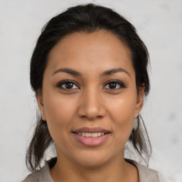 Joyful latino young-adult female with medium  brown hair and brown eyes