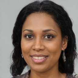 Joyful black young-adult female with medium  brown hair and brown eyes