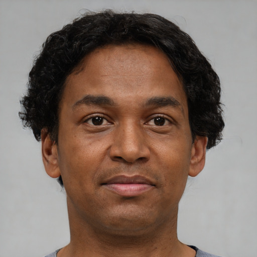 Joyful black young-adult male with short  brown hair and brown eyes