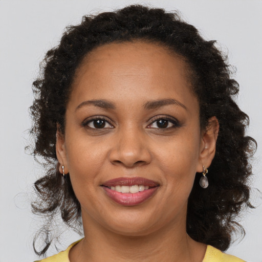 Joyful black young-adult female with medium  brown hair and brown eyes