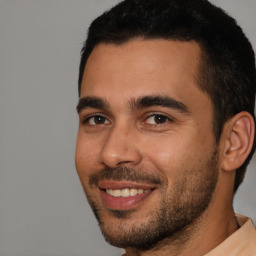 Joyful white young-adult male with short  black hair and brown eyes