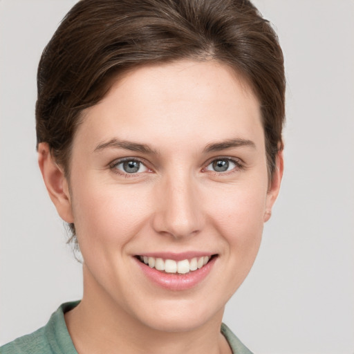 Joyful white young-adult female with short  brown hair and grey eyes