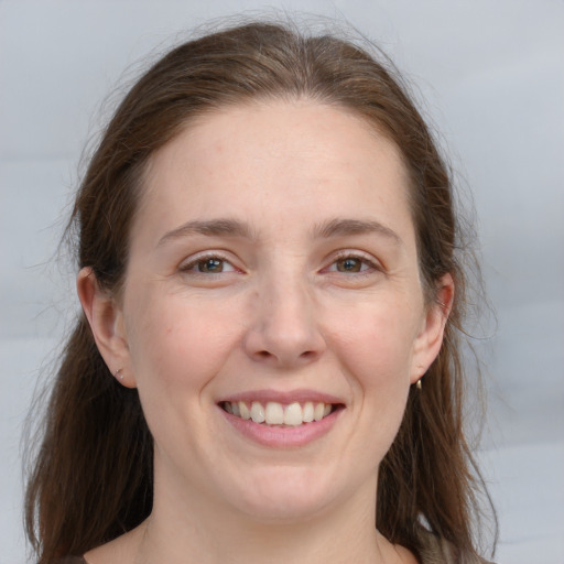 Joyful white young-adult female with long  brown hair and grey eyes