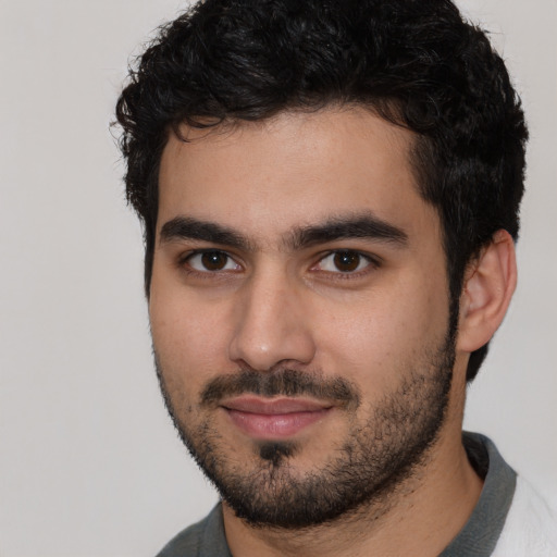 Joyful white young-adult male with short  black hair and brown eyes