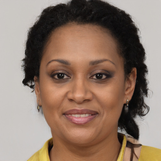 Joyful black adult female with long  brown hair and brown eyes