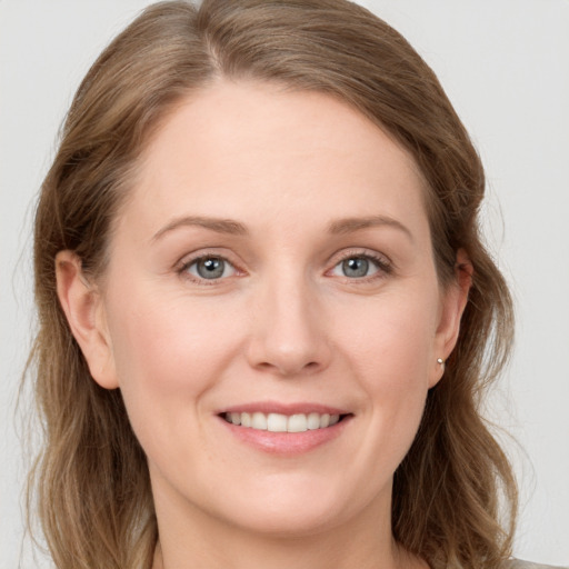 Joyful white young-adult female with long  brown hair and grey eyes