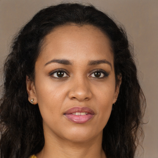 Joyful black young-adult female with long  brown hair and brown eyes