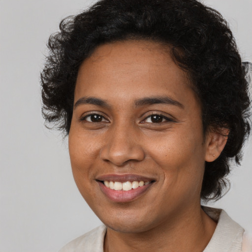 Joyful black young-adult female with medium  brown hair and brown eyes