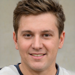 Joyful white young-adult male with short  brown hair and grey eyes