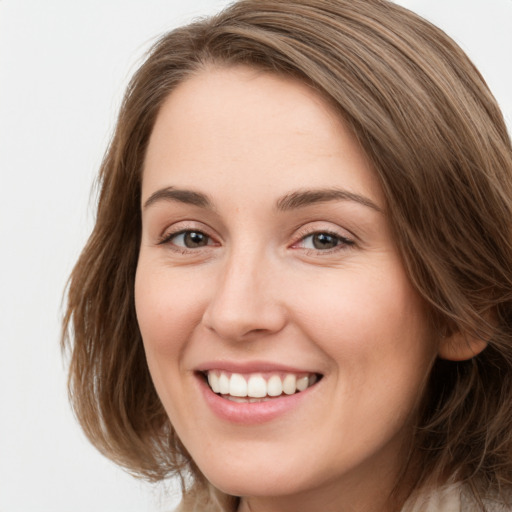 Joyful white young-adult female with long  brown hair and green eyes