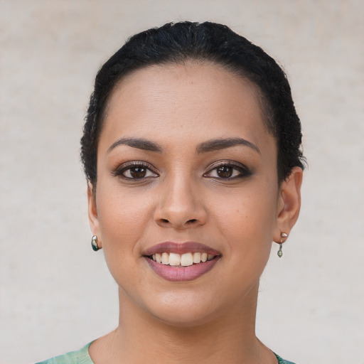 Joyful latino young-adult female with short  black hair and brown eyes