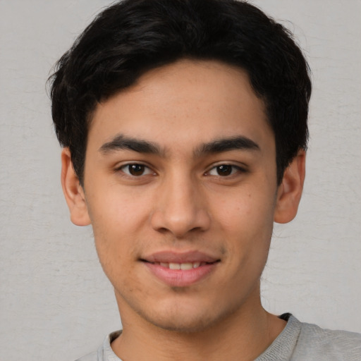 Joyful white young-adult male with short  black hair and brown eyes