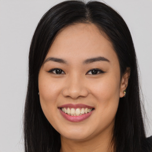 Joyful asian young-adult female with long  brown hair and brown eyes
