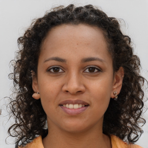 Joyful black young-adult female with long  brown hair and brown eyes