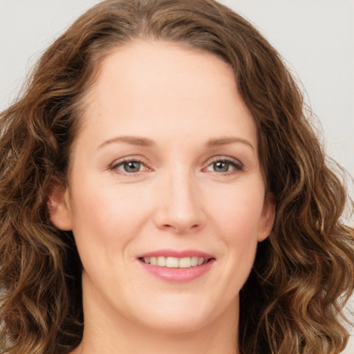 Joyful white young-adult female with long  brown hair and green eyes