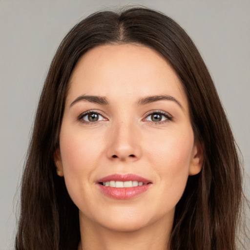 Joyful white young-adult female with long  brown hair and brown eyes