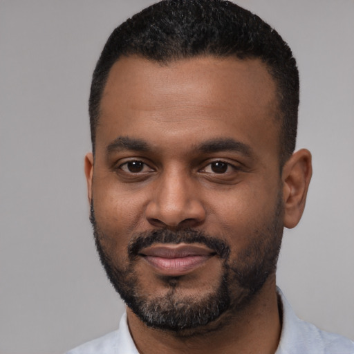Joyful black young-adult male with short  black hair and brown eyes