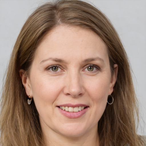 Joyful white adult female with long  brown hair and grey eyes