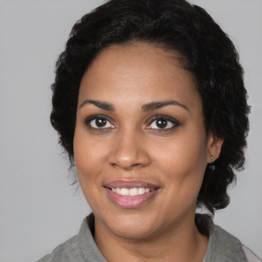 Joyful black young-adult female with medium  black hair and brown eyes