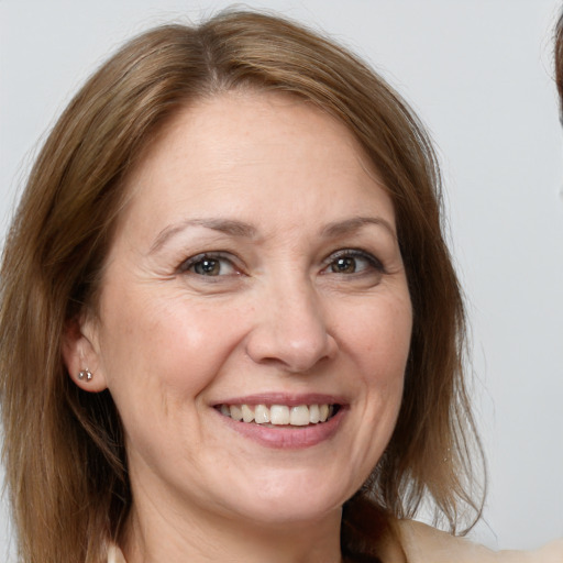 Joyful white adult female with medium  brown hair and grey eyes