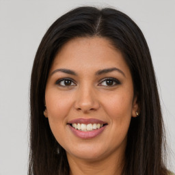 Joyful latino young-adult female with long  brown hair and brown eyes