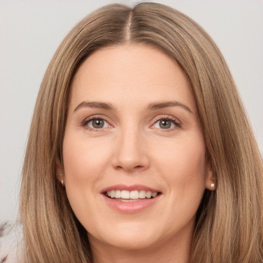 Joyful white young-adult female with long  brown hair and brown eyes