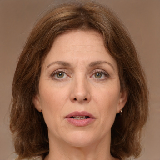 Joyful white adult female with medium  brown hair and green eyes