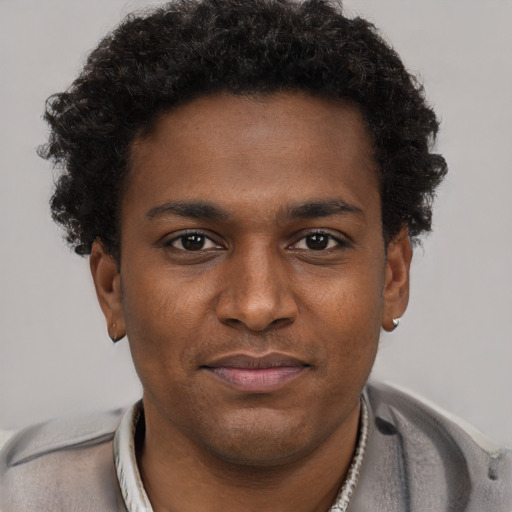 Joyful black young-adult male with short  brown hair and brown eyes