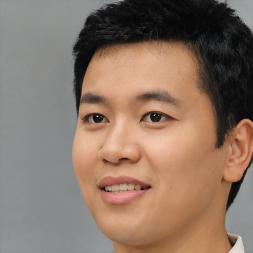 Joyful asian young-adult male with short  black hair and brown eyes