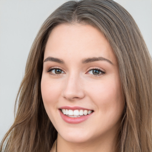 Joyful white young-adult female with long  brown hair and blue eyes