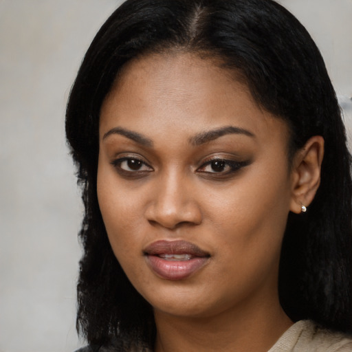 Joyful black young-adult female with long  black hair and brown eyes