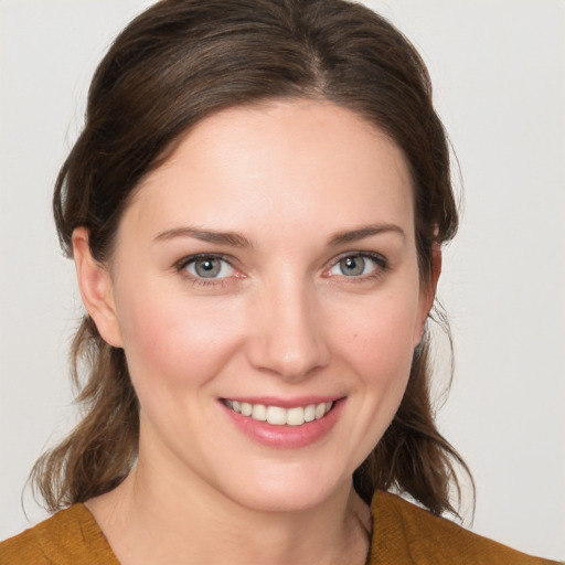 Joyful white young-adult female with medium  brown hair and grey eyes