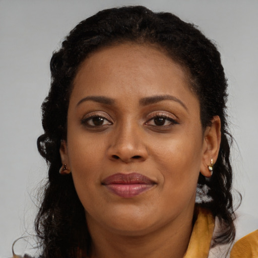Joyful black young-adult female with long  brown hair and brown eyes