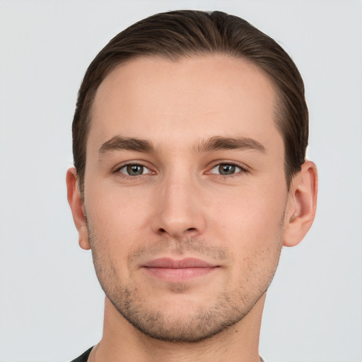 Joyful white young-adult male with short  brown hair and grey eyes