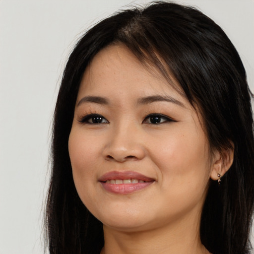 Joyful asian young-adult female with long  brown hair and brown eyes