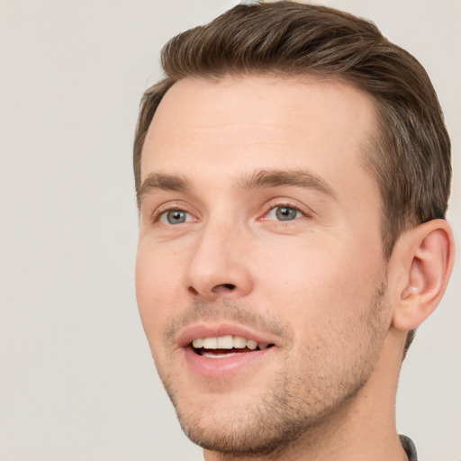 Joyful white young-adult male with short  brown hair and grey eyes