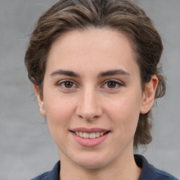 Joyful white young-adult female with medium  brown hair and grey eyes