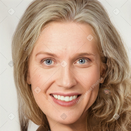 Joyful white adult female with long  brown hair and blue eyes