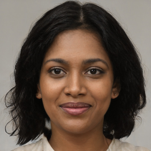 Joyful black young-adult female with medium  black hair and brown eyes