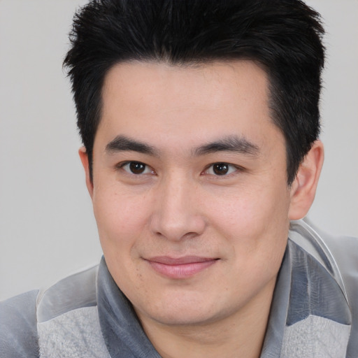 Joyful asian young-adult male with short  black hair and brown eyes