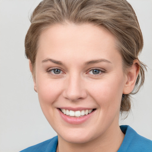 Joyful white young-adult female with medium  brown hair and blue eyes