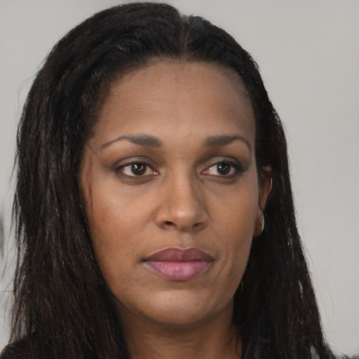 Joyful black young-adult female with long  brown hair and brown eyes