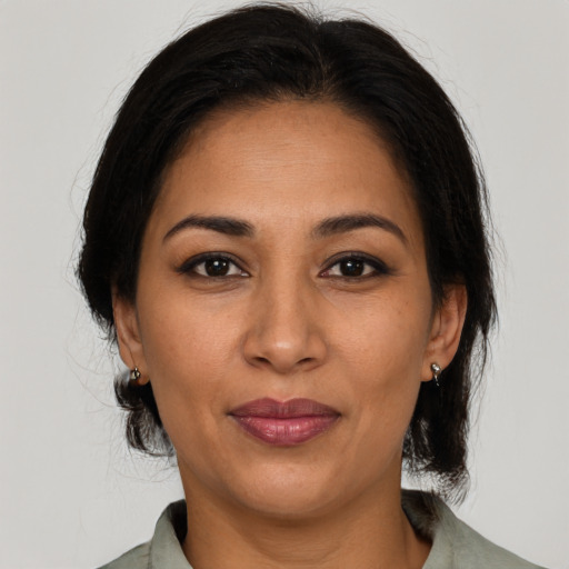 Joyful latino adult female with medium  brown hair and brown eyes