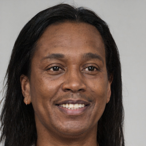 Joyful black adult male with long  brown hair and brown eyes