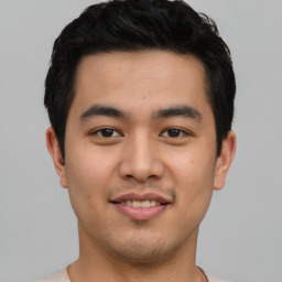 Joyful asian young-adult male with short  black hair and brown eyes