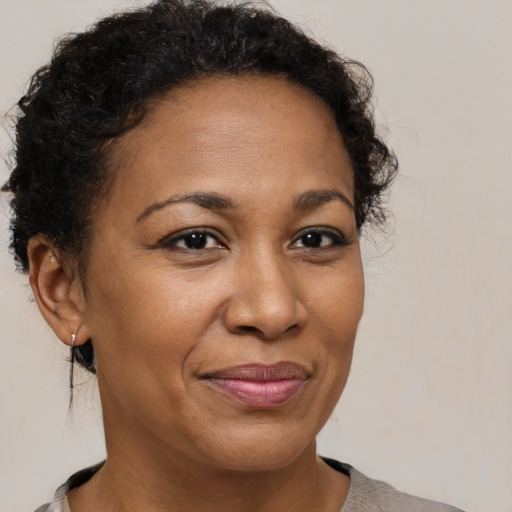 Joyful black adult female with short  brown hair and brown eyes