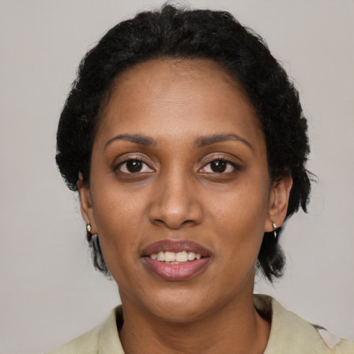 Joyful black adult female with short  black hair and brown eyes