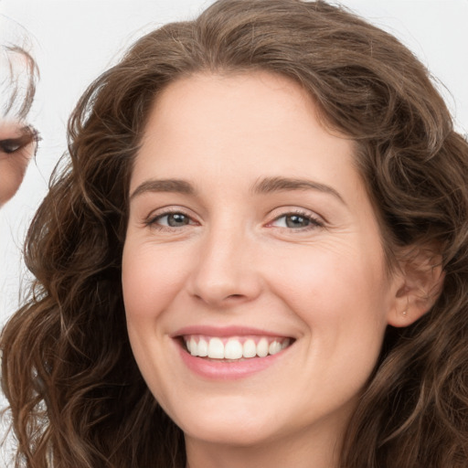 Joyful white young-adult female with long  brown hair and green eyes