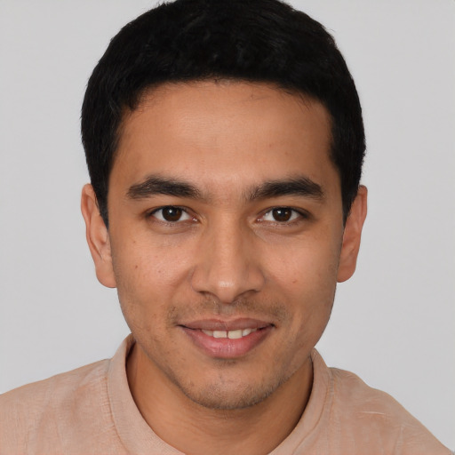 Joyful latino young-adult male with short  black hair and brown eyes